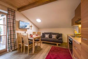 - une cuisine et une salle à manger avec une table et un canapé dans l'établissement Ferienhaus Bockstecken, à Hart im Zillertal