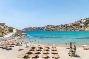 a beach with chairs and umbrellas and the ocean at Hotel Kamelo in Vari