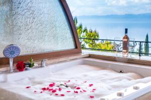 Badewanne mit Fenster und Badewanne in der Unterkunft Vila Bisera in Ohrid