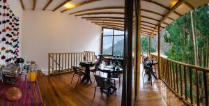 a room with tables and chairs on a balcony at Bamboo Lodge Sacred Valley in Pisac +36 photos