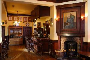 soggiorno con camino e bar di Dingle Benners Hotel a Dingle