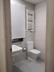 biała łazienka z toaletą i umywalką w obiekcie A Torre do Lago w mieście Valdoviño
