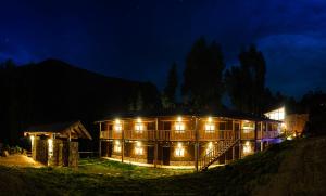 a house lit up at night with lights at Bamboo Lodge Sacred Valley in Pisac