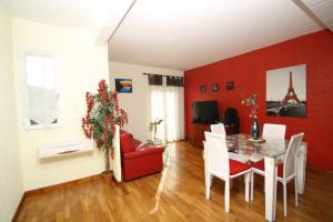 ein Esszimmer mit einer roten Wand sowie einem Tisch und Stühlen in der Unterkunft Appartement vue mer in Bastia
