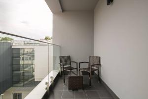 dwa krzesła na balkonie budynku w obiekcie Montevideo Centrum 15 by Grand Apartments w mieście Sopot