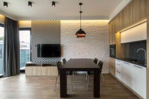 a dining room with a table and chairs in a kitchen at Montevideo Centrum 15 by Grand Apartments in Sopot