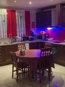 een keuken met een tafel en stoelen met paarse verlichting bij Villa Viktoriya in Arpolahti