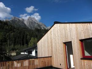 a wooden building with a mountain in the background at Ferienhaus Friedle in Leogang