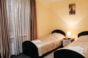 ヴォログダにあるMini-Hotel Aquarelのベッド2台と窓が備わるホテルルームです。