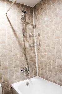 ヴォログダにあるMini-Hotel Aquarelのバスルーム(シャワー、白いバスタブ付)