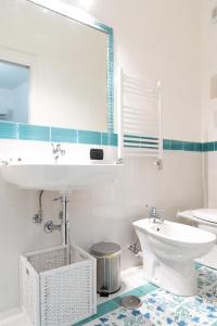 Baño blanco con lavabo y aseo en Home 41° en Formia