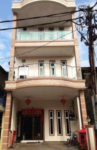 un edificio alto de color blanco con un balcón en la parte superior. en Ks Homestay en Taiping