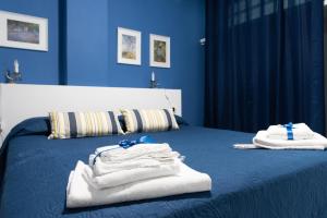 Habitación azul con cama y toallas. en Home 41°, en Formia