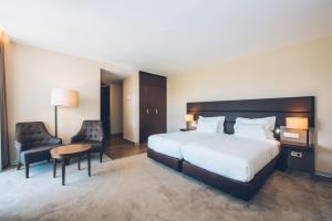 a hotel room with a bed and a table and chairs at Iberostar Selection Lagos Algarve in Lagos