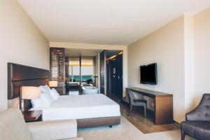 a hotel room with a bed and a desk and a couch at Iberostar Selection Lagos Algarve in Lagos