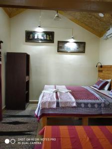 a bedroom with a bed and two pictures on the wall at Alegro Beach Homes in Palolem +17 photos