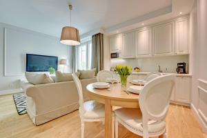 uma cozinha e sala de estar com uma mesa e um sofá em Montevideo Centrum 4 by Grand Apartments em Sopot