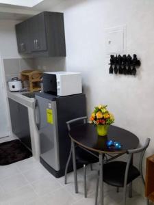 a small kitchen with a table and a microwave at EAM LAKE VIEW @ TAGAYTAY PRIME RESIDENCES in Tagaytay