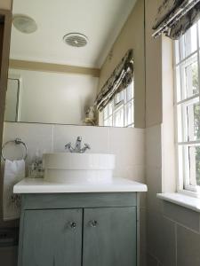a bathroom with a sink and a mirror at Almond Cottage Bed & Breakfast in Somerset West