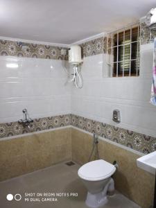 a bathroom with a toilet and a sink at Alegro Beach Homes in Palolem