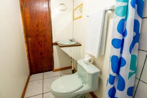 a bathroom with a toilet and a sink at Cabinas Arrecife in Cahuita