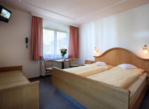 A bed or beds in a room at Pension Lärchenbrunn