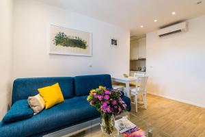 a living room with a blue couch and a table at Apartments Tereza in Dubrovnik