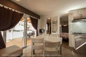 a kitchen and living room with a table and chairs at Camping Da Giovanni in Peschiera del Garda