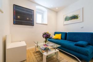 a living room with a blue couch and a table at Apartments Tereza in Dubrovnik