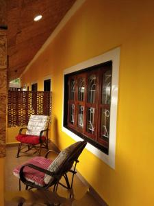 a room with two chairs and a window on a wall at Alegro Beach Homes in Palolem