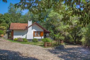 una pequeña casa blanca con techo rojo en Graz Hauser Cabañas en Villa General Belgrano