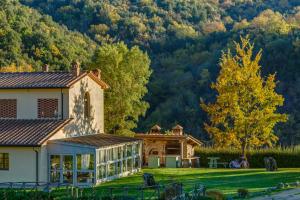 una casa con jardín y montañas en el fondo en La Grotta dell'Eremita, en Gambassi Terme