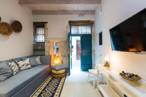 a living room with a couch and a tv at Daria's Ηome in Rethymno