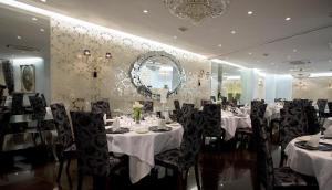 a dining room with tables and chairs and a mirror at B&B HOTEL Salamanca Centro Artheus in Salamanca