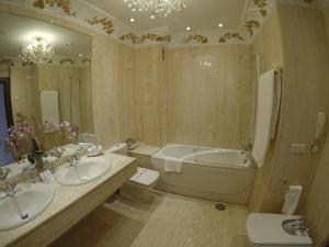 a bathroom with two sinks and a tub and a toilet at B&B HOTEL Salamanca Centro Artheus in Salamanca +31 photos