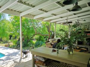 a person sitting on a patio with a table at Almond Cottage Bed & Breakfast in Somerset West