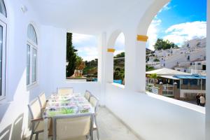 a table and chairs on the balcony of a house at AT Almoraide Rooms Suites in Nerja
