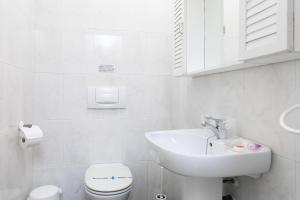a white bathroom with a sink and a toilet at AT Almoraide Rooms Suites in Nerja