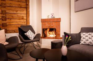 a living room with a couch and a fireplace at De Gamlas Hem Hotel & Restaurant in Oulu