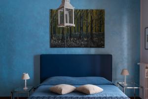a blue bedroom with a blue bed with two pillows at KiBari B&B in Bari