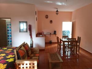 - un salon avec un canapé, une table et des chaises dans l'établissement Hotel Villas Monteli Suites Cuernavaca, à Cuernavaca