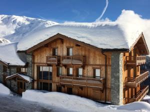 a large wooden house with snow on the roof at Residence Miravidi La Rosiere in La Rosière
