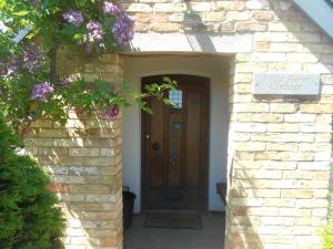 einen Eingang zu einem Backsteinhaus mit einer Holztür in der Unterkunft Villa Farm Cottage in Thornton Curtis