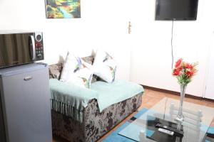 uma sala de estar com um sofá e uma mesa de vidro em Harmony Guest House em Joanesburgo