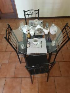 uma mesa de vidro com cadeiras e pratos em Harmony Guest House em Joanesburgo