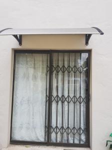 uma janela com um portão de ferro preto em Harmony Guest House em Joanesburgo