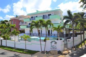ein Gebäude mit Palmen davor in der Unterkunft Casa Verde Hotel - Steps to the Beach, Pool, Restaurant & Bar in Rincon