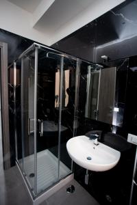 een badkamer met een glazen douche en een wastafel bij Amazing Napoli in Napels