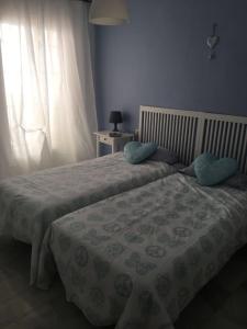 1 dormitorio con 2 camas con almohadas y ventana en Moderno apartamento con piscina disponible según restricciones sequía, en Torremolinos