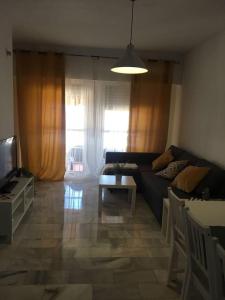 多列毛利诺斯Apartamento con aire acondicionado en urbanización con piscina的客厅里有一张沙发和一张桌子。